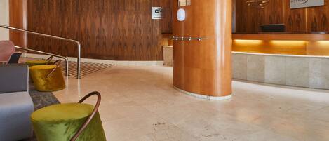 Zona de recepción de un hotel con pared de madera, mostrador de recepción e indicación de disponibilidad de Wi-Fi.