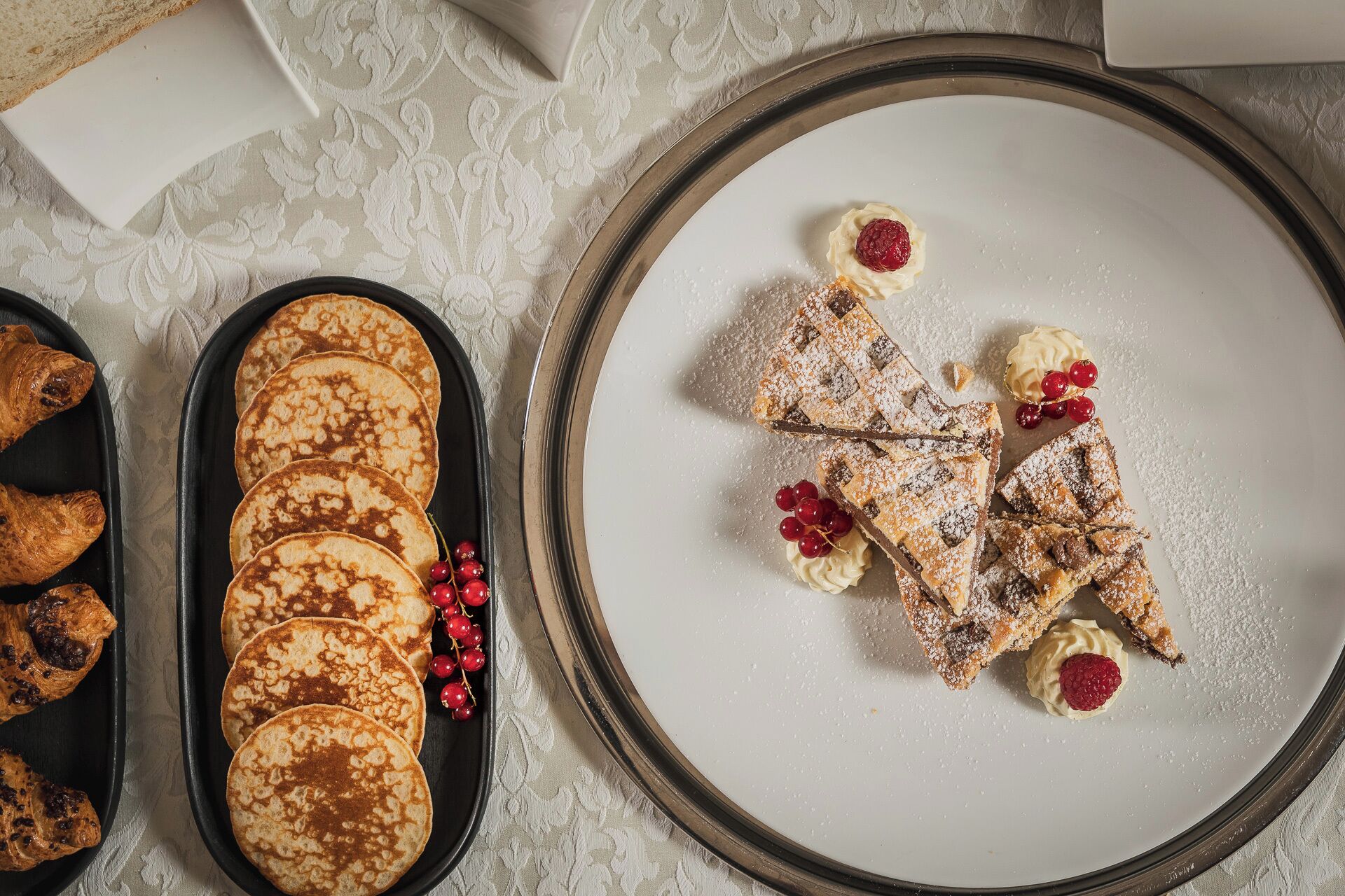 A tray of pancakes and a plate with waffles and berries.