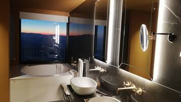 Ein modernes Badezimmer mit einer großen Badewanne, zwei Waschbecken und einem großen Spiegel.