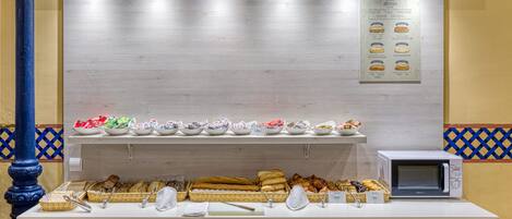Una barra de buffet con distintos alimentos y utensilios.