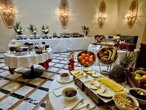 A buffet setup with various food items and a checkered floor. - Hotel Nouvel (Barcelona)