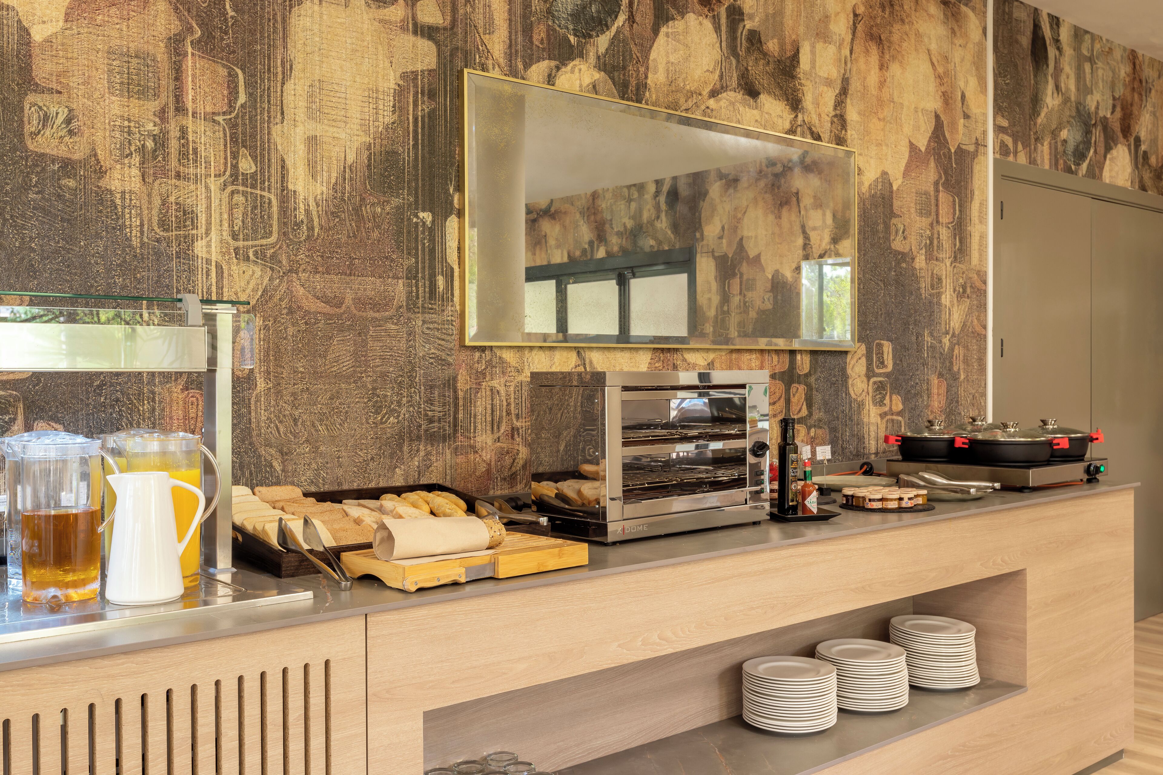 Un bar pour prendre le petit-déjeuner, équipé d’une machine à café, d’un grille-pain et d’un grand miroir placé au-dessus.