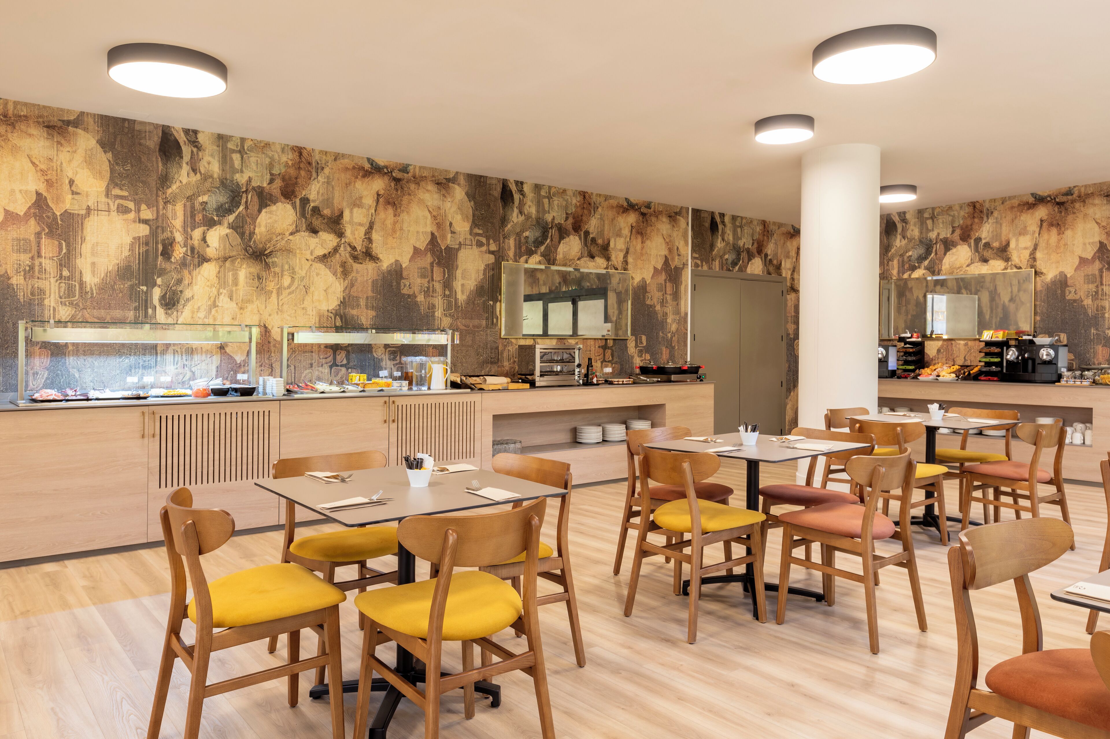Een restaurant met houten tafels en stoelen, een buffet en een muurschildering.
