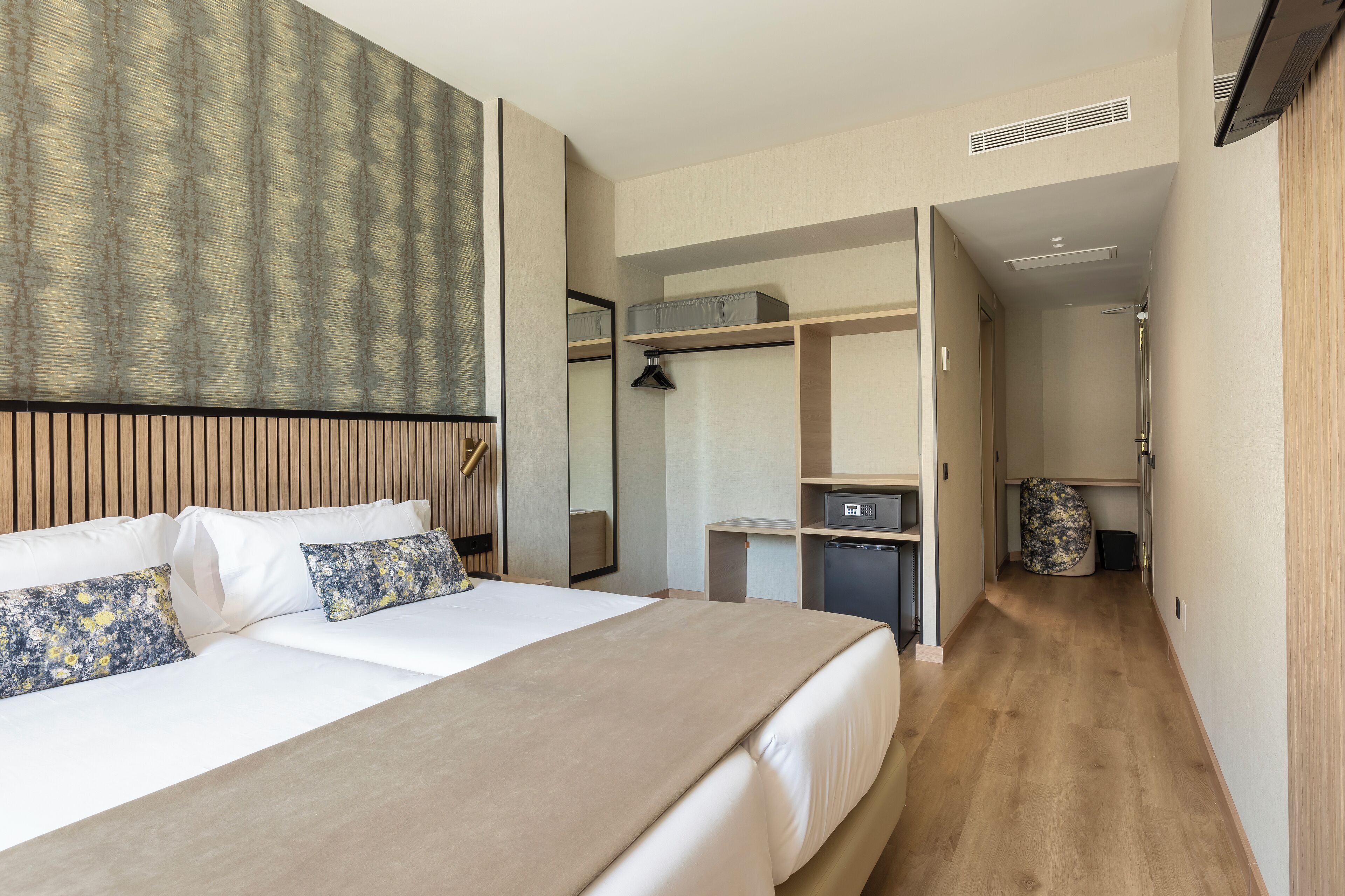 Een hotelkamer met een groot bed, een kledingkast, een bureau en een inloopkast.
