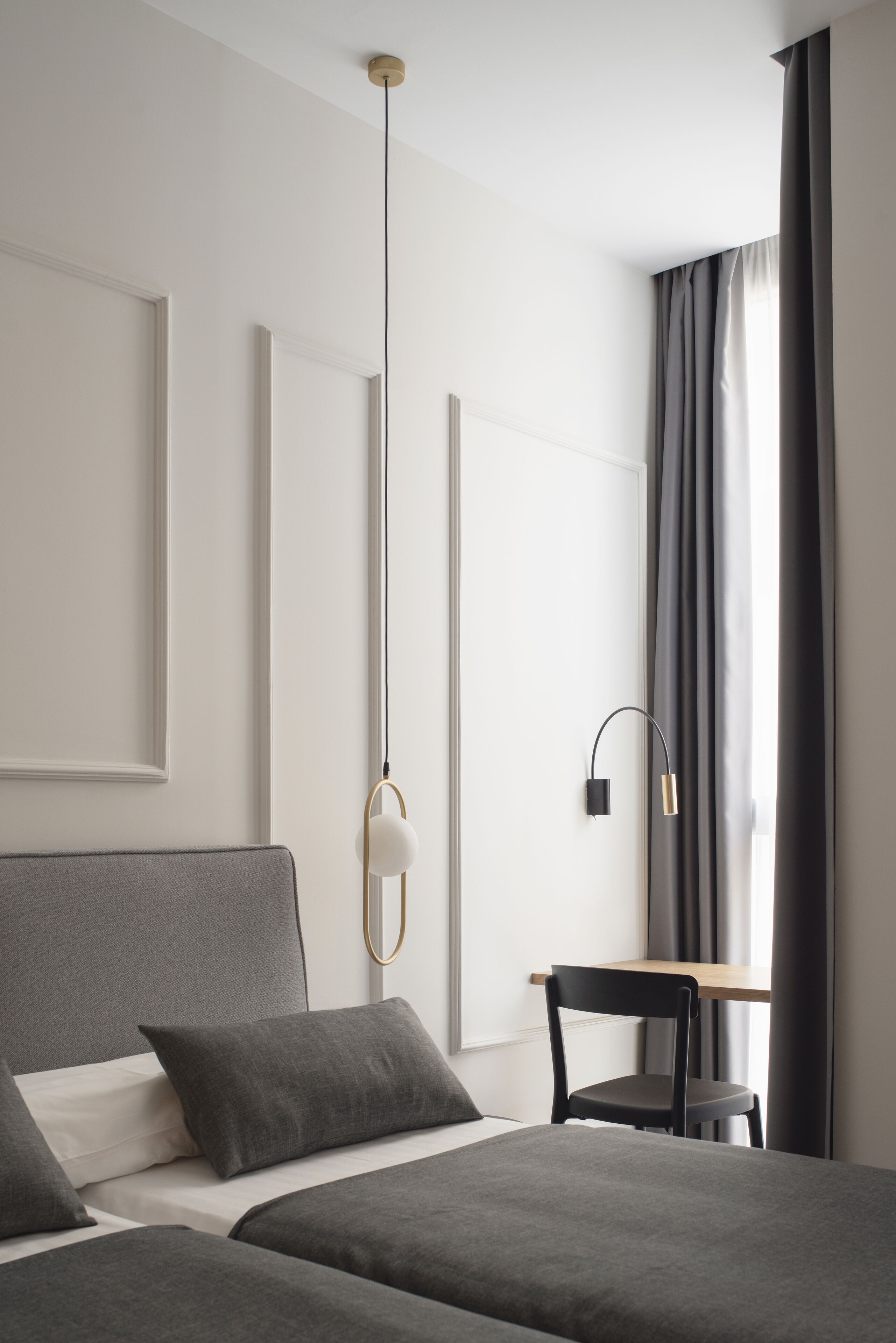 Una habitación de hotel moderna con una cama grande, un escritorio y una silla.