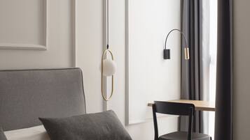 Una habitación de hotel moderna con una cama grande, un escritorio y una silla.