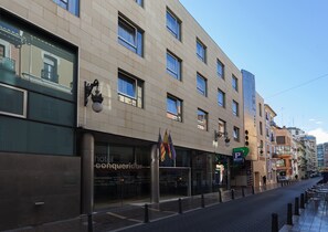 A hotel with a modern facade, large windows, and a welcoming entrance.