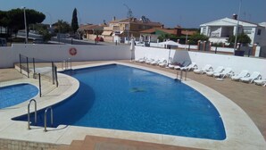 A swimming pool with a tiled deck, a lifebuoy, and a row of white lounge chairs. - Hotel Carabela Santa Maria (Moguer)