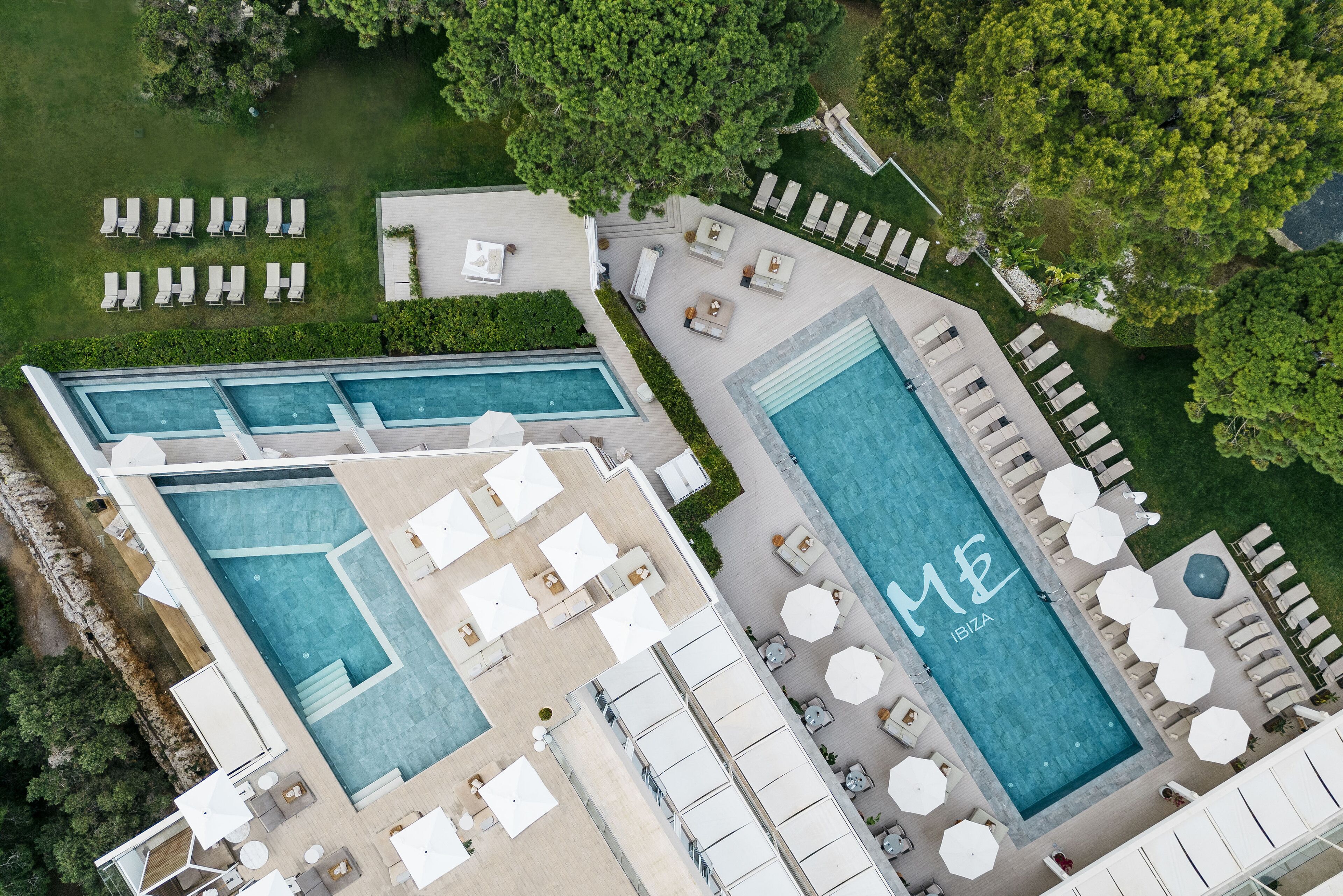Un área de piscina en la azotea con múltiples piscinas, tumbonas y zonas de estar al aire libre.