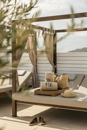 A sunlit outdoor seating area with a wooden bench, a woven basket, and a pair of shoes on the floor. - ME Ibiza - The Leading Hotels of the World (Santa Eulalia del Rio)