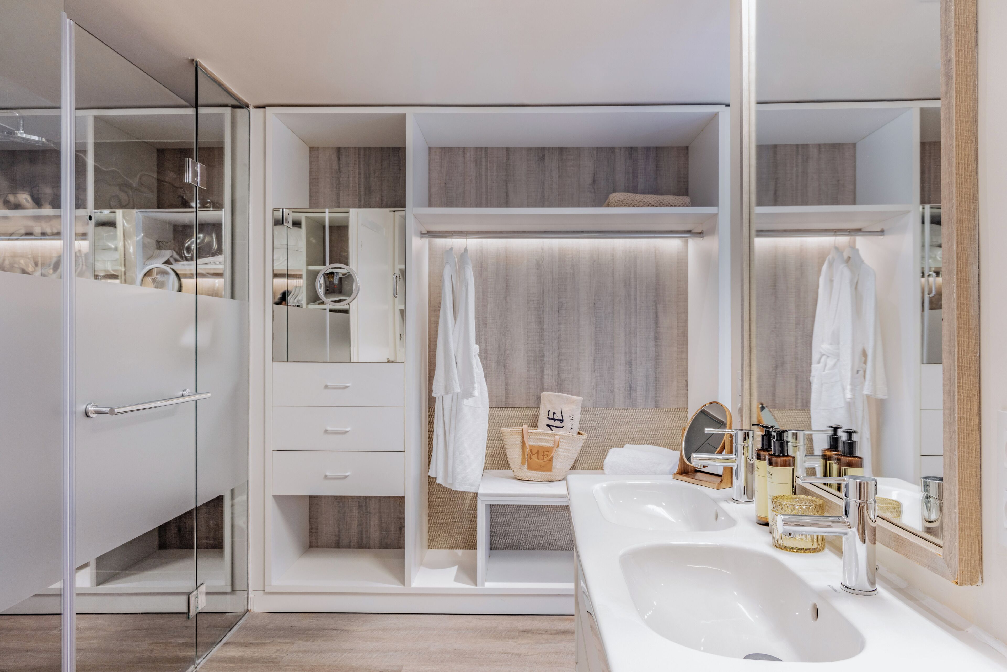 Une salle de bain moderne avec une douche à parois de verre, un meuble-lavabo et un miroir.