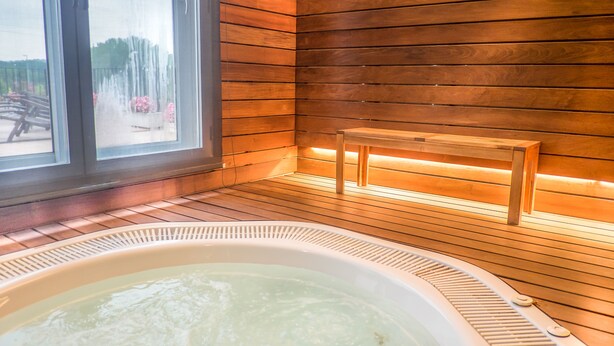 A hot tub with wooden walls and a bench. - Hotel Costabella (Girona)