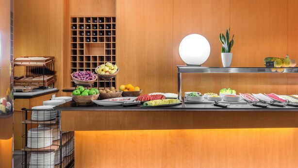 Ein reichhaltiges Buffet mit verschiedenen Speisen und einem Weinregal.