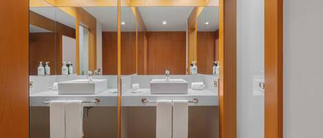 A modern bathroom with two sinks, mirrors, and wooden paneling.