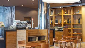 Un interior de cafetería moderno con mobiliario de madera, una barra de café y una vitrina con vinos.