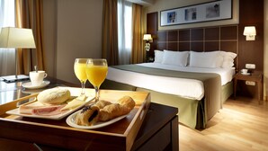 A hotel room with a bed, a tray with breakfast items, and a window with curtains. - Hotel Dorma Tartessos (Huelva)
