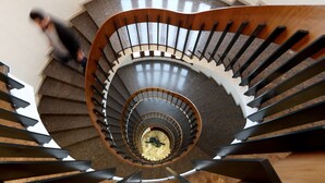 A spiral staircase with a central column and wooden handrails. - Hotel Dorma Tartessos (Huelva)