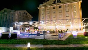 A large building with a formal architectural style, featuring a central courtyard with a pool and outdoor seating area. - Hotel Velada Mérida (Merida)