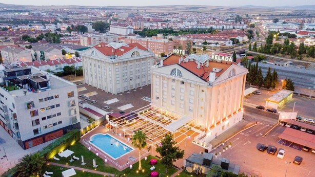 A hotel with a large central building, a swimming pool, and a parking lot. - Hotel Velada Mérida (Merida)