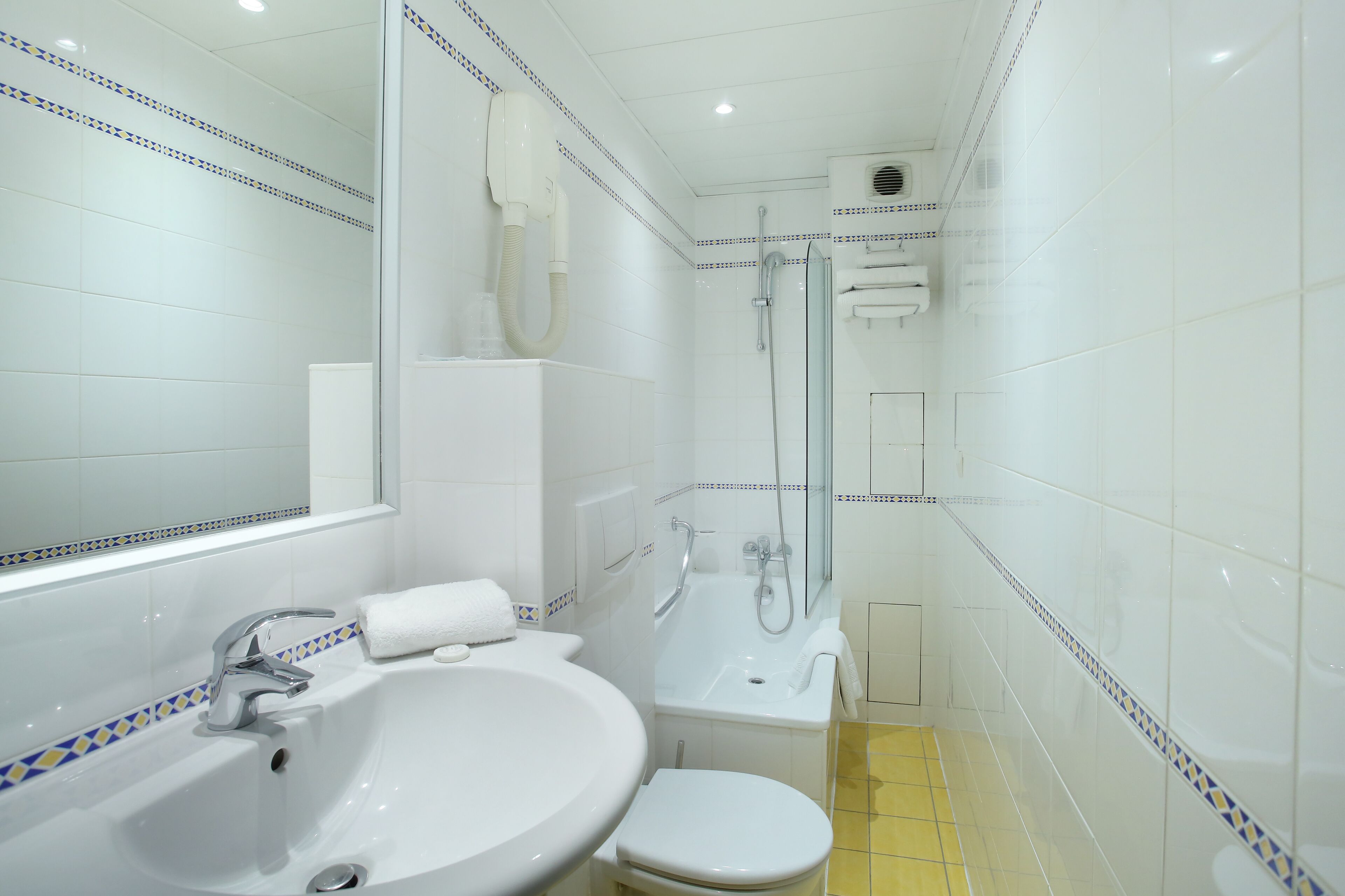 Un baño con lavamanos, inodoro y ducha.