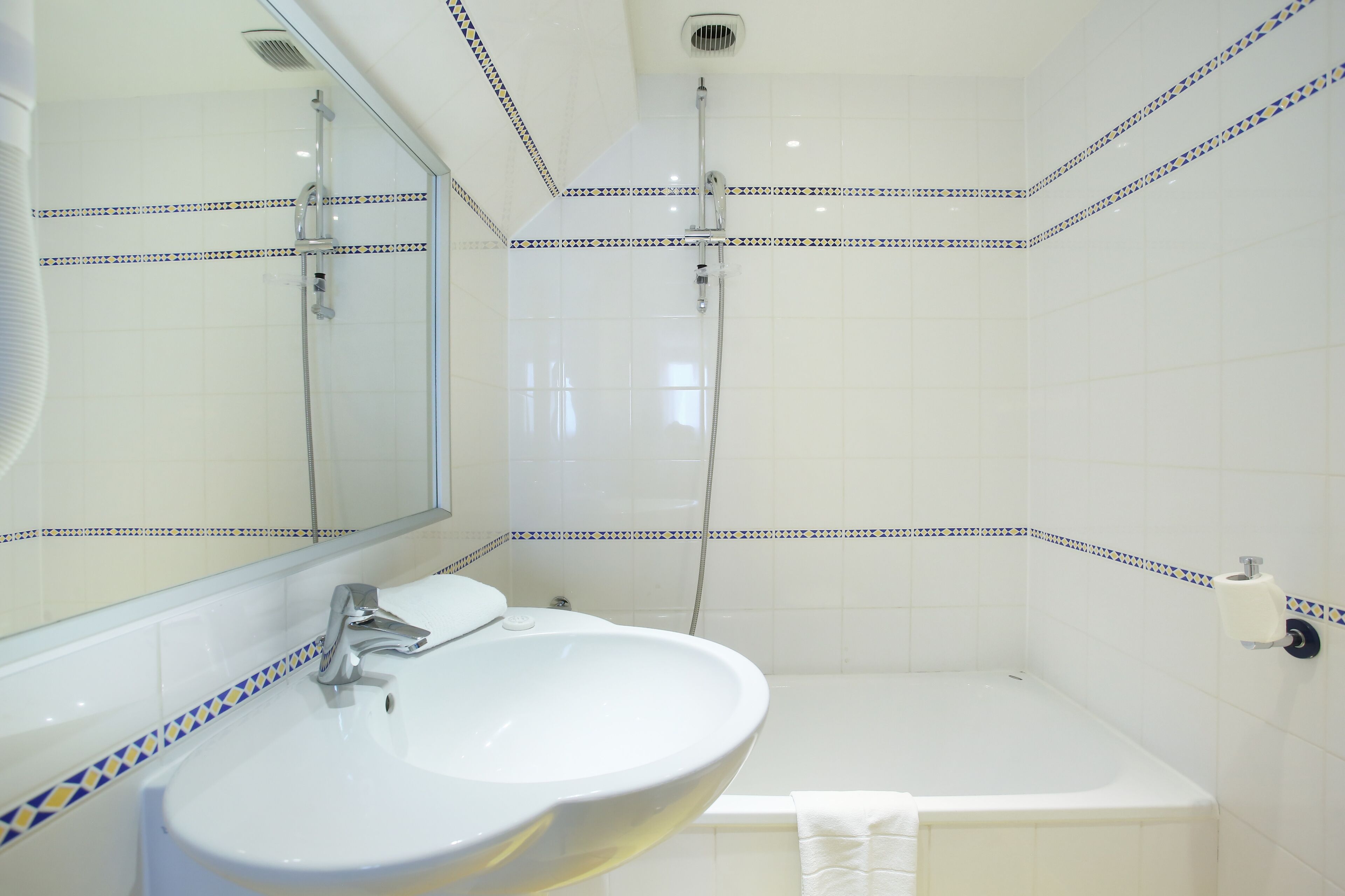 A bathroom with a white sink, a mirror, and a shower.
