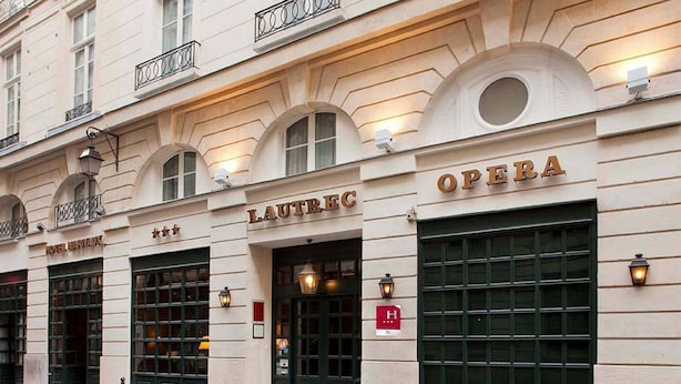 Un edificio con fachada clásica, que muestra los nombres 'LAUTREC' y 'OPERA' de forma destacada.