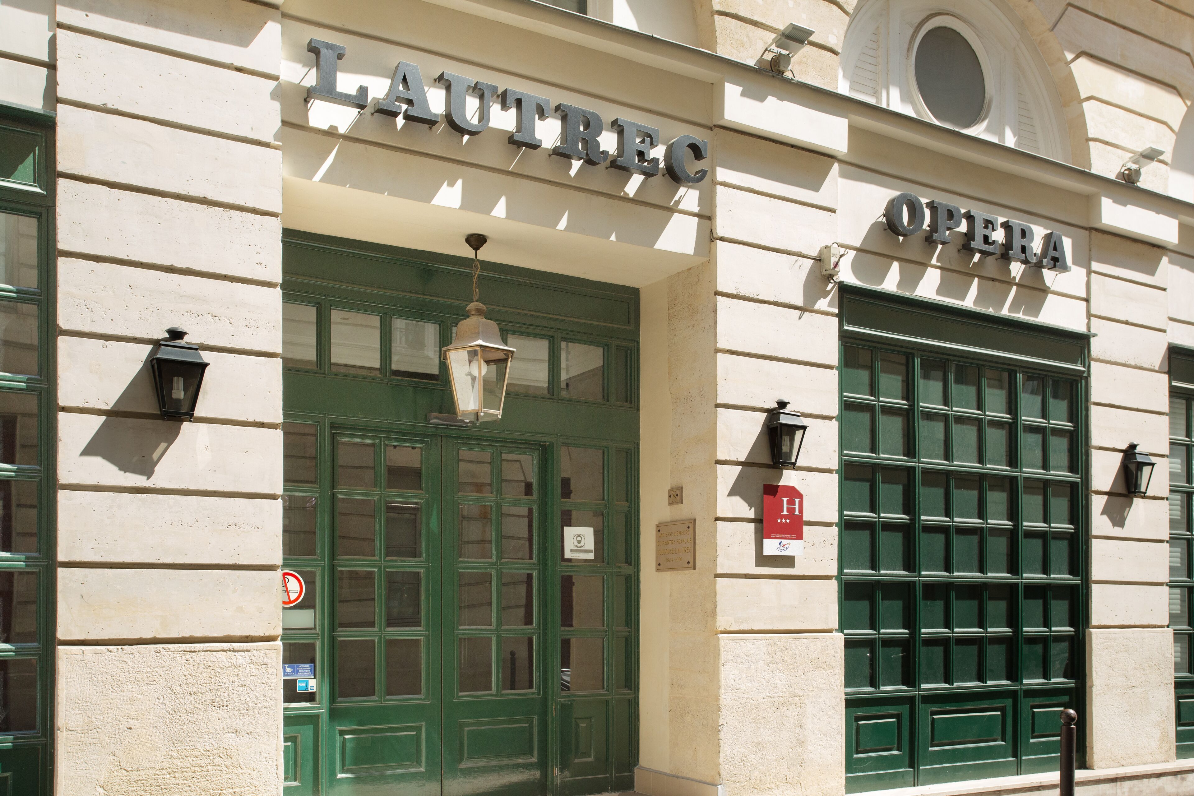 Eine Gebäudefassade mit der Aufschrift "LAUTREC" und "OPERA", die auf ein Theater oder eine Kulturstätte hindeutet.