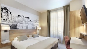 Una habitación de hotel con una cama grande, lámparas de noche, un escritorio con silla, un televisor y un mural en la pared de un puente.