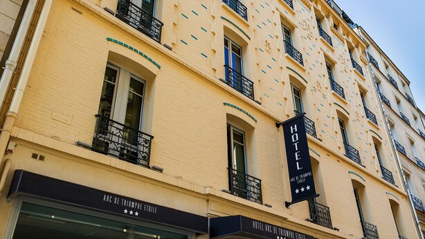 Fachada de hotel con entrada despejada, varios balcones y un cartel llamativo que dice 'HOTEL'.