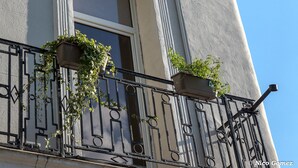 Un hotel con un letrero que dice "Hotel St. James" y un balcón con plantas en macetas.
