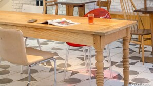A modern dining area with a wooden table, chairs, and hanging pendant lights. - Greet Hotel Marseille Centre St Charles (Marseille)
