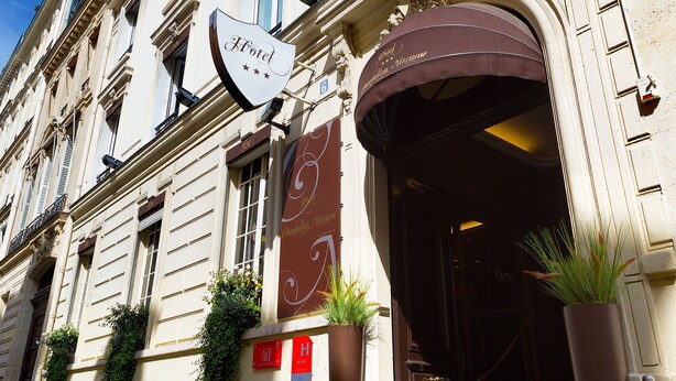 A historic building with a prominent entrance, a sign indicating a hotel, and decorative ironwork. - Hôtel Chambellan Morgane (Paris)