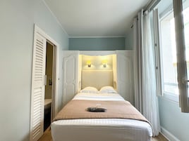 Una camera da letto con un letto, due lampade da comodino, una porta e una finestra.