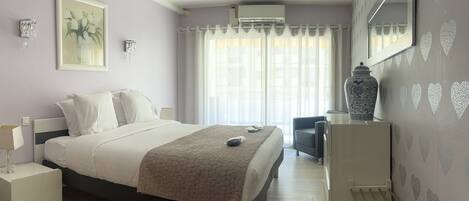 Habitación de hotel con cama, mesita de noche, silla y un jarrón decorativo.