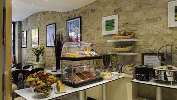 Ein Frühstücksbuffet mit verschiedenen Speisen und einer Kaffeemaschine.