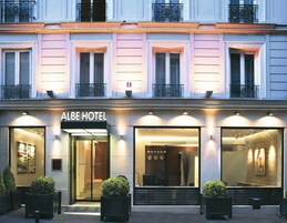 El exterior del Hotel Albe, con fachada moderna, amplias ventanas y un letrero sobre la entrada.