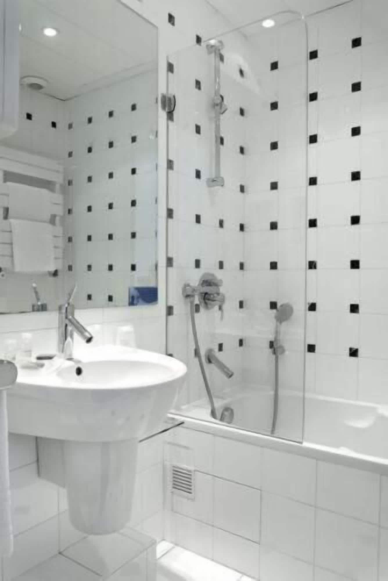 Une salle de bain moderne avec une douche à parois de verre, un lavabo blanc et une baignoire.