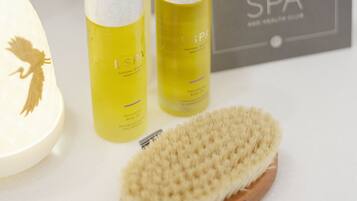 A bathroom vanity with a white countertop, a wooden brush, and two bottles of ESPA spa products.