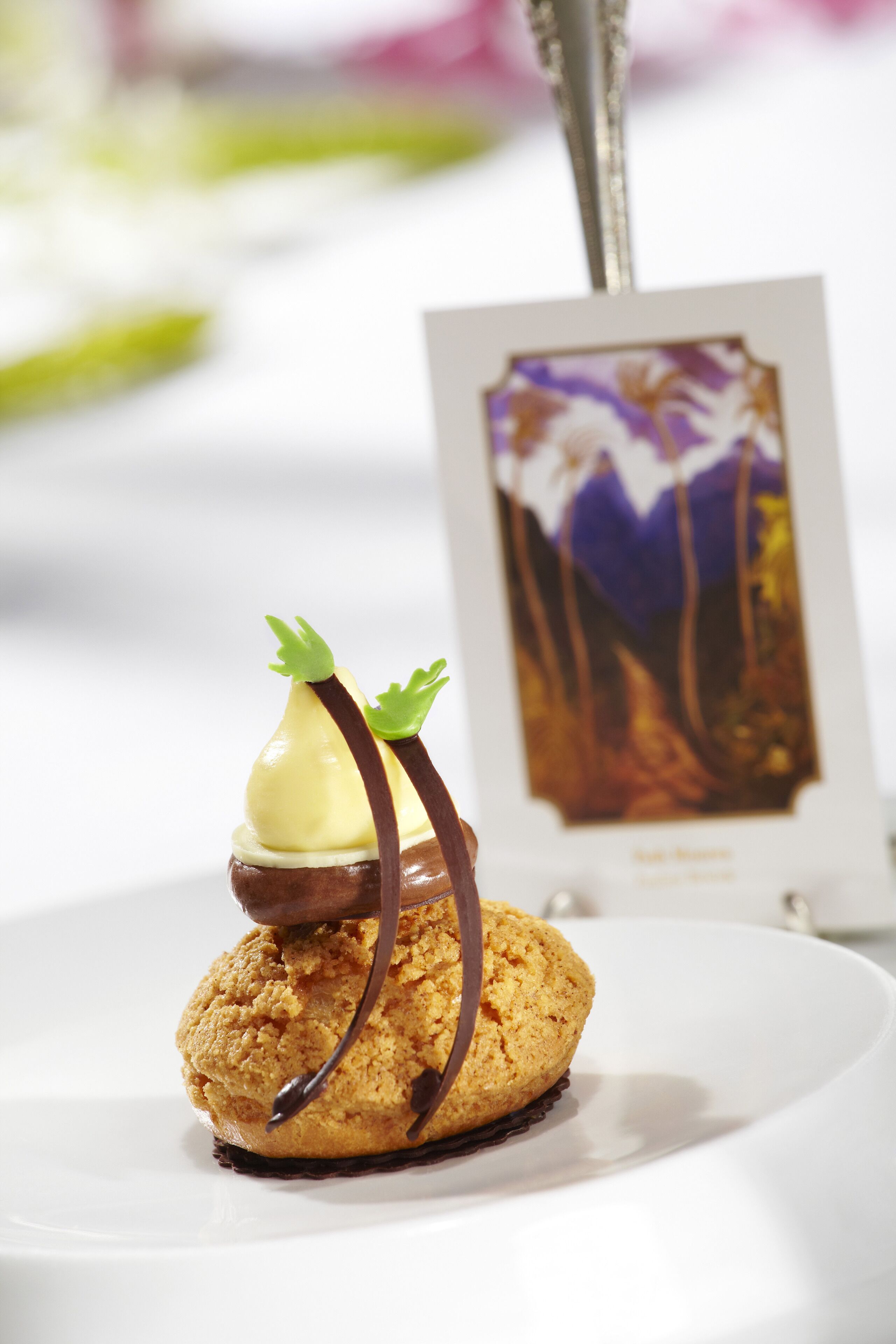 Un postre con salsa de chocolate y un pequeño adorno verde sobre un plato blanco.