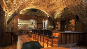 A rustic bar with wooden furniture and a brick ceiling. - The Merrion (Dublin)