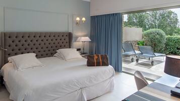 Een hotelkamer met een groot bed, een bureau met stoel en uitzicht op het omliggende landschap.
