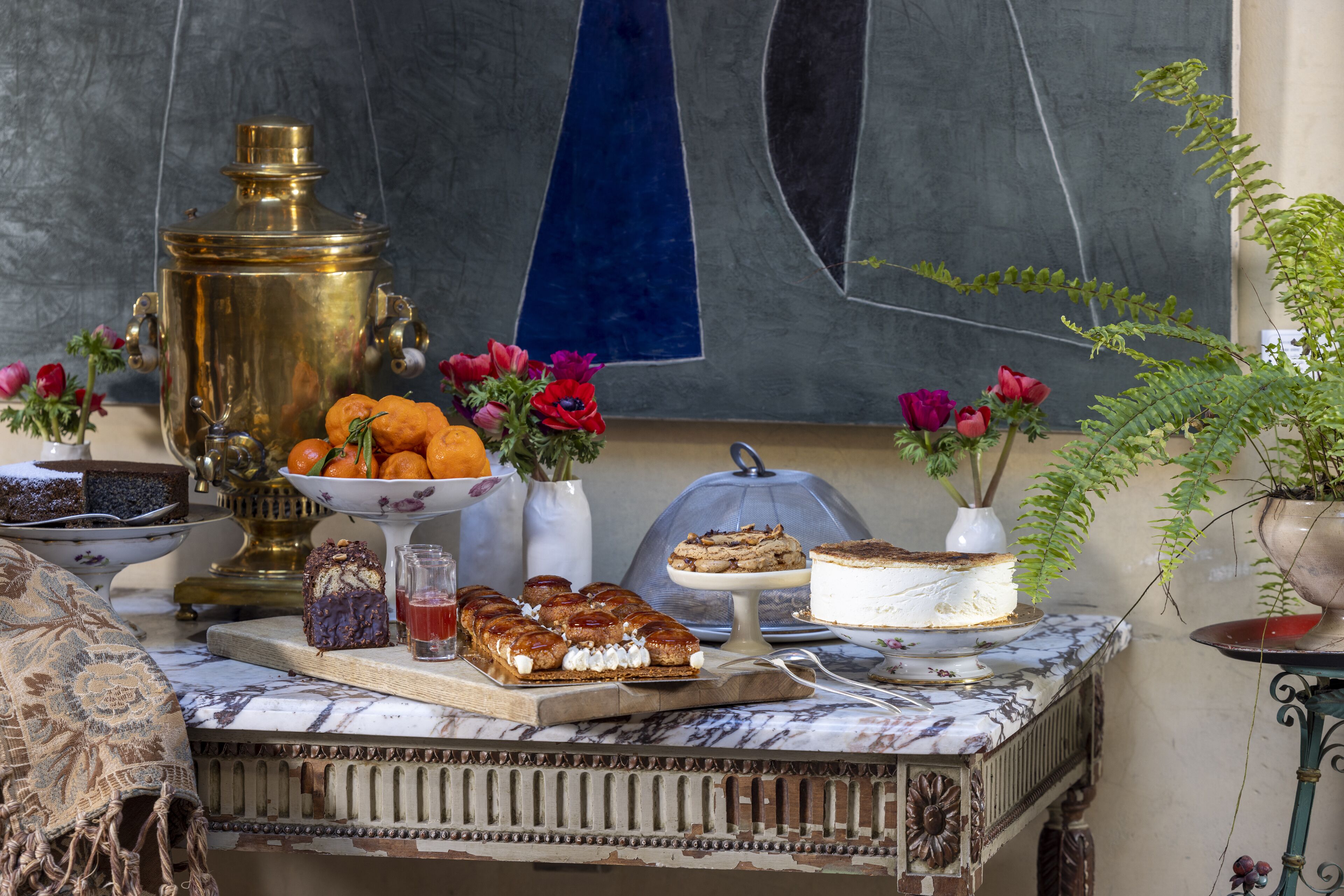 A table with various desserts and a samovar.