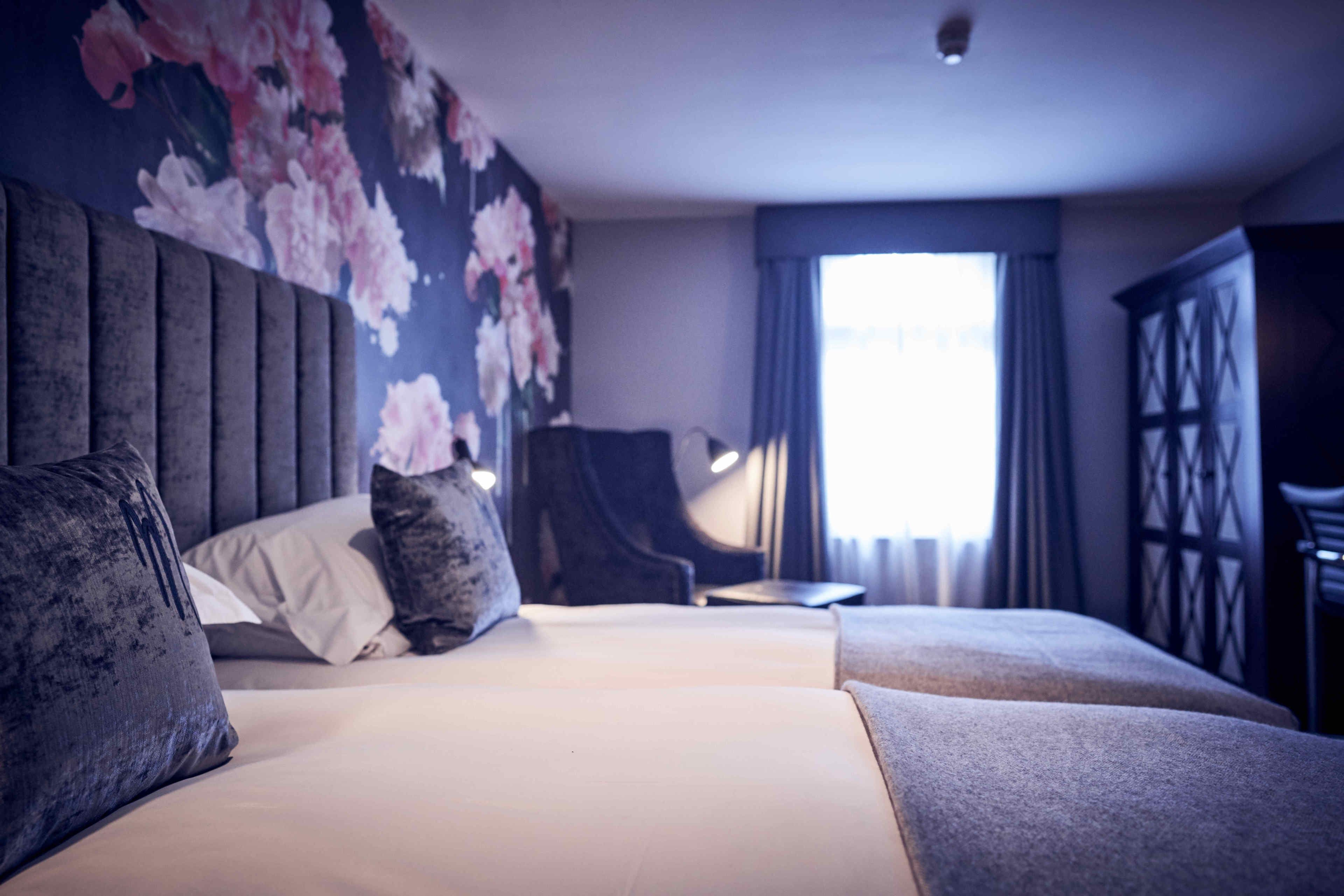 Una habitación de hotel con una cama grande, una silla, un escritorio y un armario.