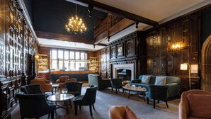 A spacious lounge with a fireplace, comfortable seating, and a bar area.