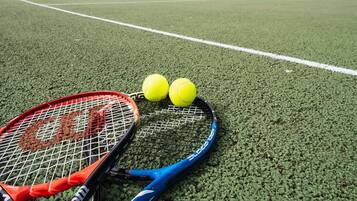 Una cancha de tenis con dos raquetas y dos pelotas.