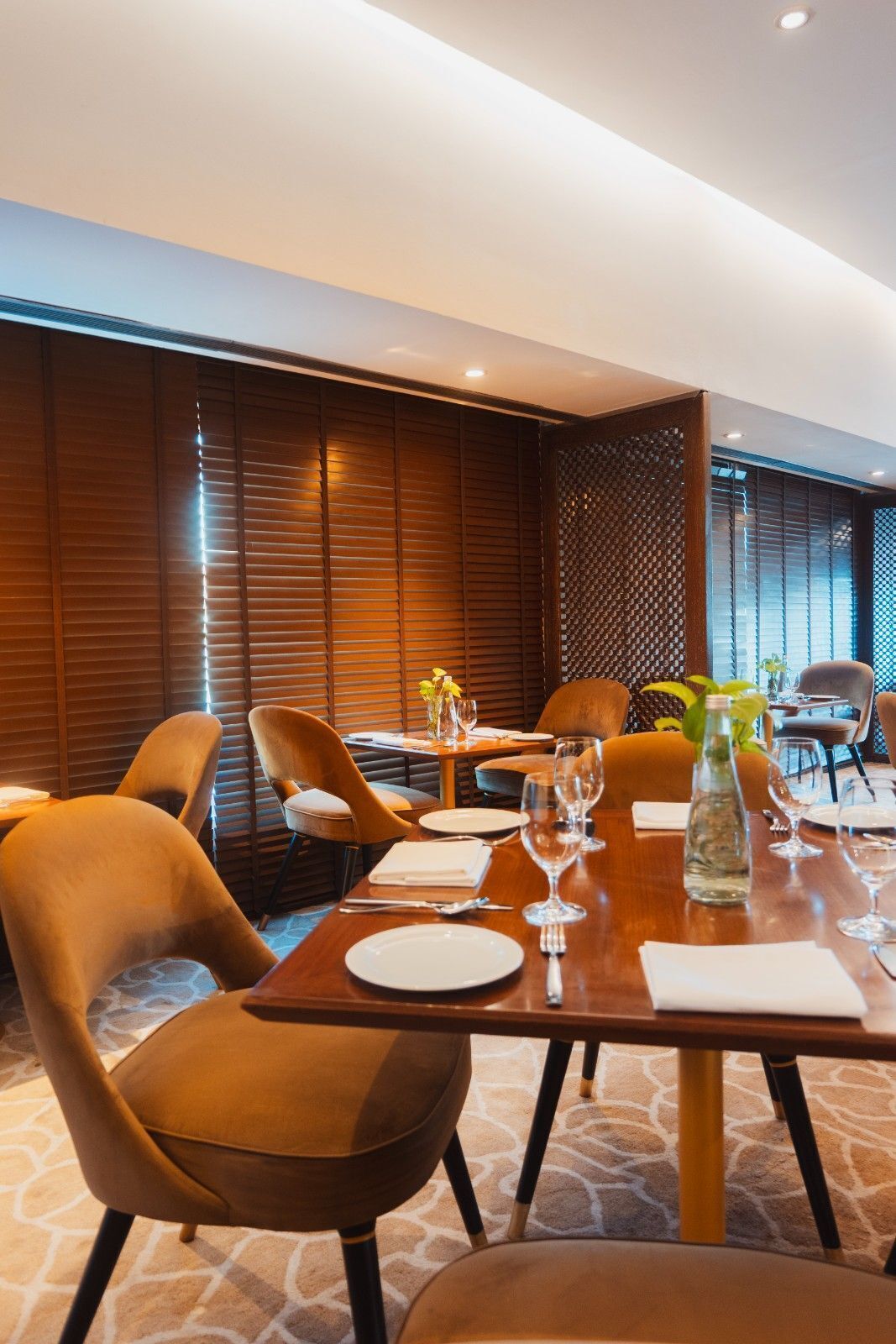 A dining area with a wooden table set for four, surrounded by cushioned chairs.