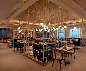 A modern interior with a central bar area, seating arrangements, and decorative lighting. - The Park New Delhi (New Delhi)