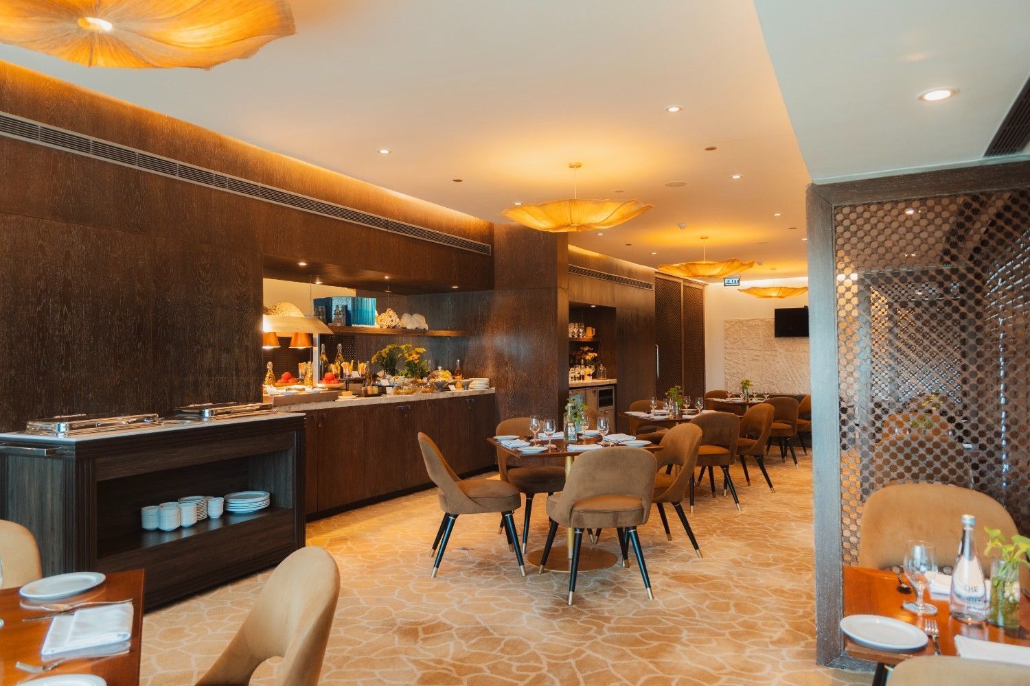 A modern restaurant with a bar area, dining tables, and chairs.