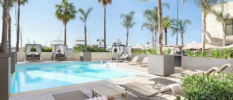 Una piscina al aire libre de temporada, sombrillas