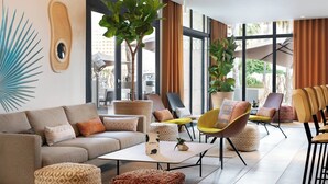 Un área de descanso moderna con sofá, sillones y una mesa de centro.